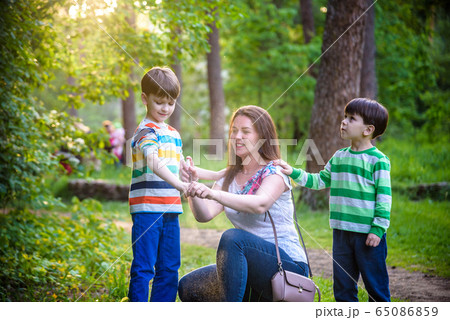 Young woman mother applying insect repellent to 65086859