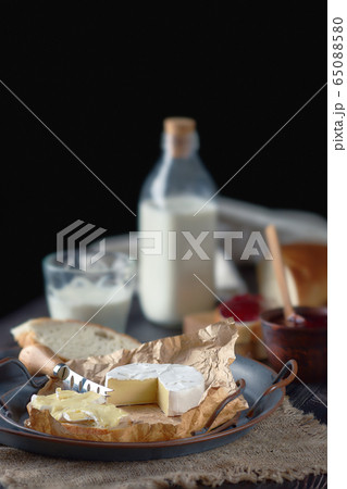Rustic country breakfast with brie cheese, milk, baguette and cranberry jam 65088580