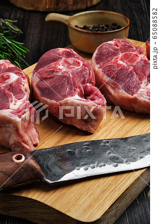 Close up view of raw fresh lamb shank on cutting board with spice Close up view of raw fresh lamb shank on cutting board with spice 65088582