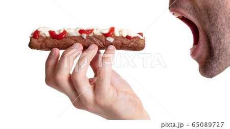 Man eating a frikadel with ketchup, mayonnaise on 65089727