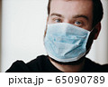 Portrait of man wearing a protective medical face mask to prevent infection of coronavirus. 65090789
