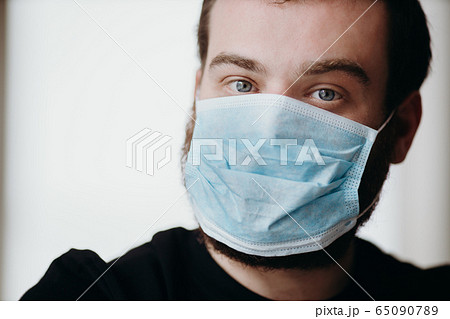 Portrait of man wearing a protective medical face mask to prevent infection of coronavirus. Portrait of man wearing a protective medical face mask to prevent infection of coronavirus. 65090789