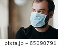 Portrait of man wearing a protective medical face mask to prevent infection of coronavirus. 65090791