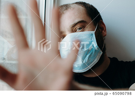 Coronavirus. Sick man of corona virus looking through the window and wearing mask protection. Coronavirus. Sick man of corona virus looking through the window and wearing mask protection. 65090798