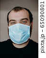 Portrait of man wearing a protective medical face mask to prevent infection of coronavirus. 65090801