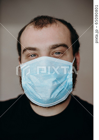 Portrait of man wearing a protective medical face mask to prevent infection of coronavirus. 65090801