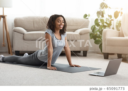 Black Girl Practicing Yoga At Home With Laptop, Watching Online Tutorials Black Girl Practicing Yoga At Home With Laptop, Watching Online Tutorials 65091773