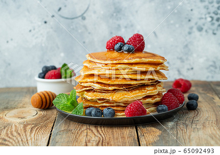 Delicious pancakes, with fresh berries and honey. 65092493