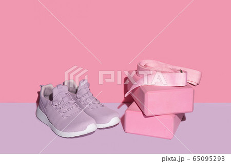 New purple sneakers, pink yogs blocks and strap on colorful background with copy space. New purple sneakers, pink yogs blocks and strap on colorful background with copy space. 65095293