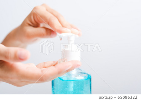 Close up woman applying press dispenser sanitizer 65096322