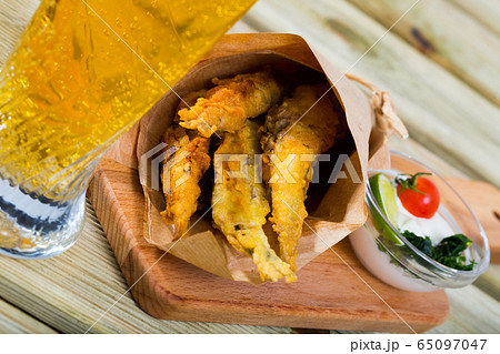 Fried in batter anchovies with creamy cheese sauce and greens Fried in batter anchovies with creamy cheese sauce and greens 65097047