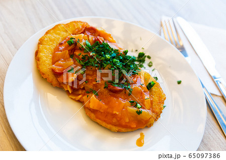 Belarusian draniki with vegetable and sausage stew Belarusian draniki with vegetable and sausage stew 65097386