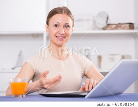 Cheerful woman using laptop Cheerful woman using laptop 65098154
