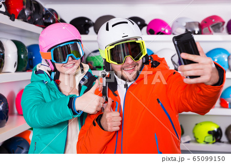 Happy couple in skiing outfit making selfie 65099150