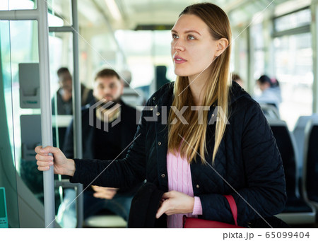 Young woman traveling by city bus Young woman traveling by city bus 65099404