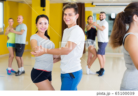 Cheerful dancing couples learning salsa Cheerful dancing couples learning salsa 65100039