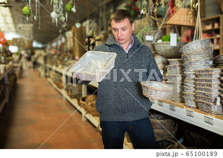 Puzzled man choosing wickerwork in shop 65100189