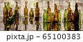 Abstract collage with colored bottles on a reflective surface 65100383