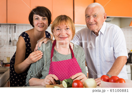 Senior couple and their daughter cooking Senior couple and their daughter cooking 65100881
