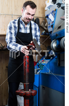 male worker fixing failed shoes in shoe repair workshop male worker fixing failed shoes in shoe repair workshop 65101020