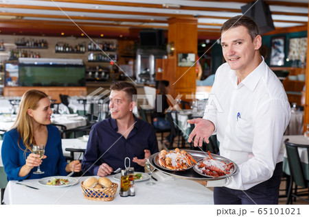 Waiter showing tray of lobsters 65101021