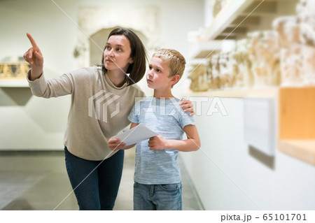 Woman and boy observing sculptures exhibition 65101701