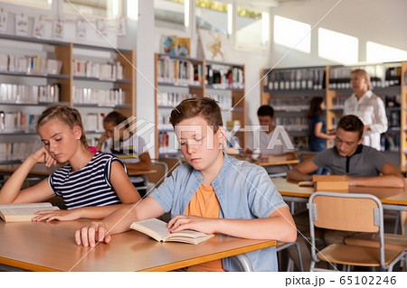 Schoolers reading in college library Schoolers reading in college library 65102246