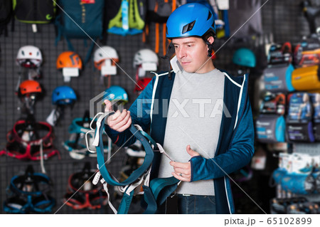 Adult sportsman choosing a sports equipment 65102899