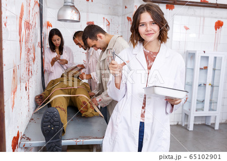 Cheerful girl in escape room stylized as medical room Cheerful girl in escape room stylized as medical room 65102901
