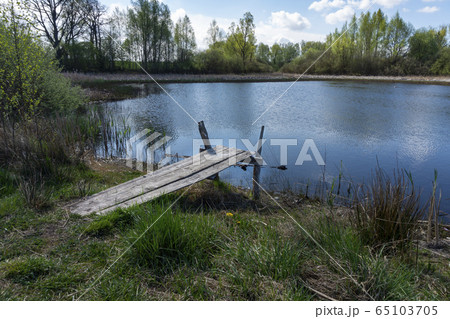 Old rustic wooden jetty on a tranquil lake 65103705