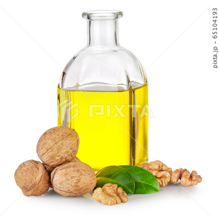 Bottle of walnut oil and walnuts with green leaves 65104193
