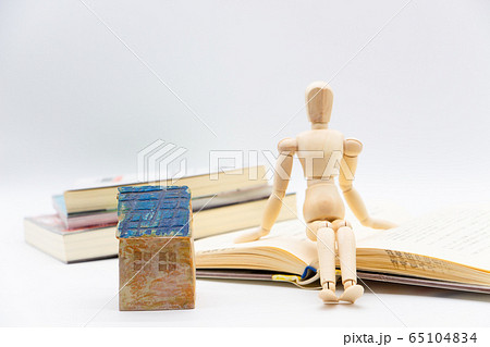 室内で退屈そうな人物　暇つぶしに本を読んでいる 65104834