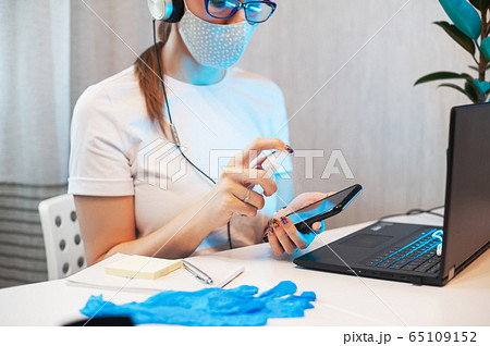 Woman disinfects the surface of the phone Woman disinfects the surface of the phone 65109152