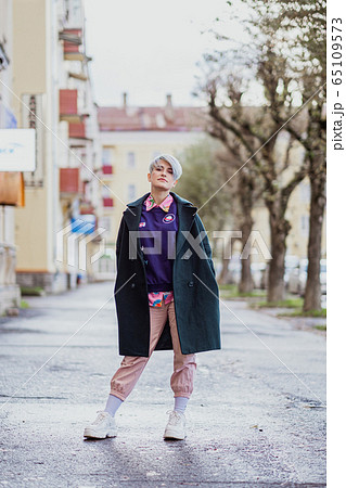 Portrait of a young beautiful woman with a short haircut and dyed hair. Grey main color and yellow, green, blue and red hair color. Portrait of a young beautiful woman with a short haircut and dyed hair. Grey main color and yellow, green, blue and red hair color. 65109573