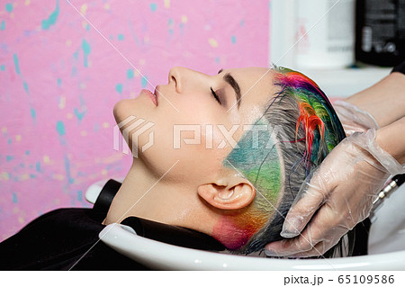 The hairdresser washes the head of a woman to a client. Colouring. The hairdresser washes the head of a woman to a client. Colouring. 65109586