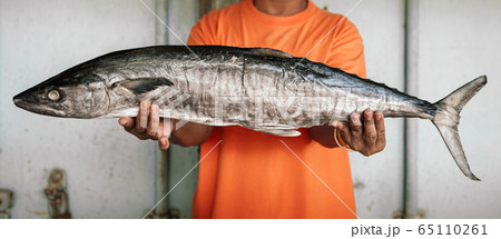 Salted mackerels fish or Pla Insee Kem. Seafood in fisherman hands 65110261