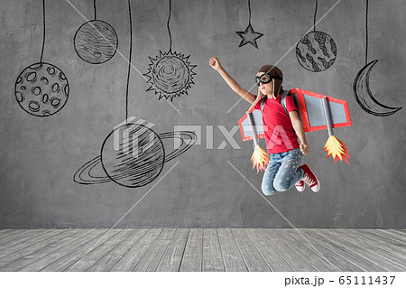 Happy child with toy paper wings playing at home 65111437