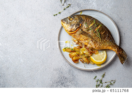 Grilled sea bream or dorada on gray plate. Gray background 65111768
