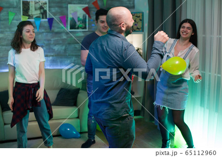 Gathering of young people dancing in an apartment 65112960