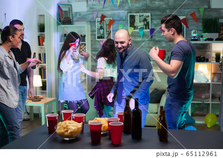 Handsome bald man dancing while partying Handsome bald man dancing while partying 65112961