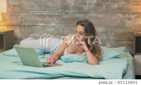 Zoom out shot of beautiful woman wearing pajamas Zoom out shot of beautiful woman wearing pajamas 65113601