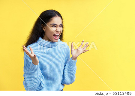 Screaming emotional angry black woman on yellow background 65115409