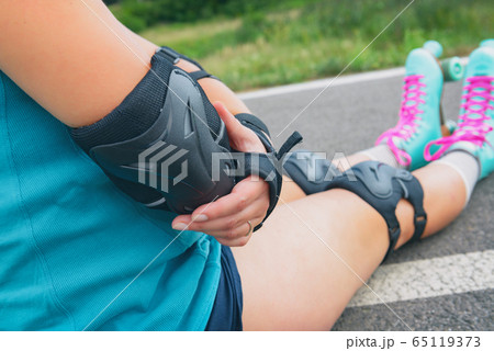 Woman rollerskater with elbow protector pads on 65119373