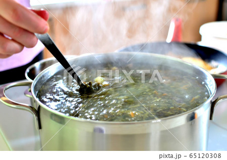 Woman preparing soup in the house on the electric stove 65120308