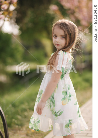 Adorable little girl walk barefoot in the park. Happy kid spent time on the fresh air. End of quarantine Adorable little girl walk barefoot in the park. Happy kid spent time on the fresh air. End of quarantine 65120450