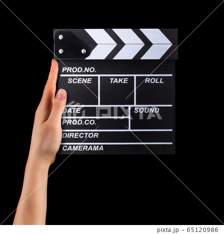Human hand holding film clapper board isolated on black background 65120986