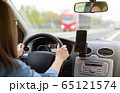 A woman driving a car on a fast road 65121574