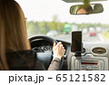 A woman driving a car on a fast road 65121582
