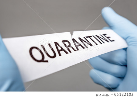 Hands in medical gloves tearing a piece of paper 65122102