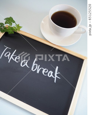 コーヒーの入った白いカップと"Take a break"というメッセージが書かれた黒板 65125520